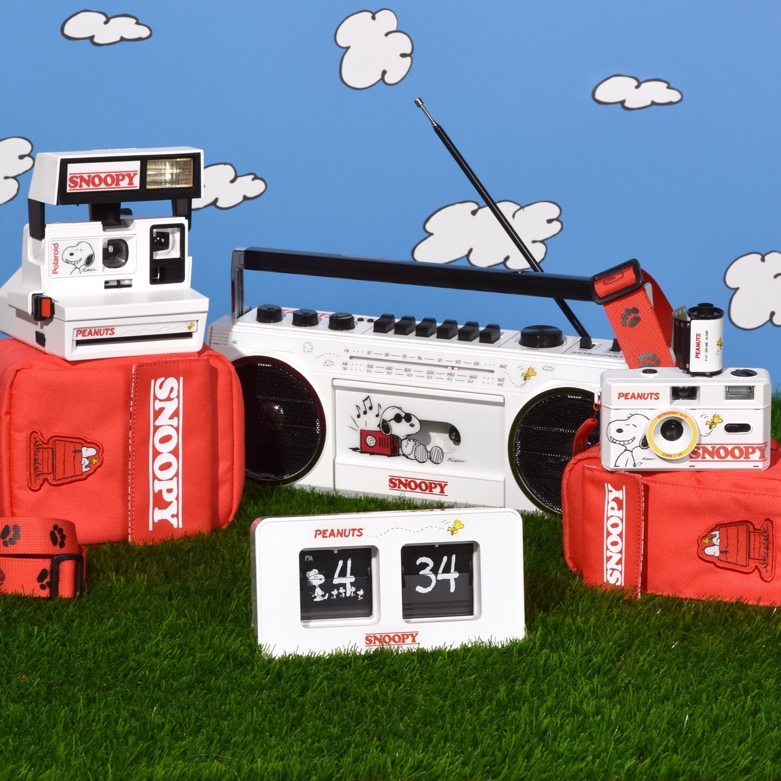 The Snoopy collection of products sitting on grass in front of a blue sky background.