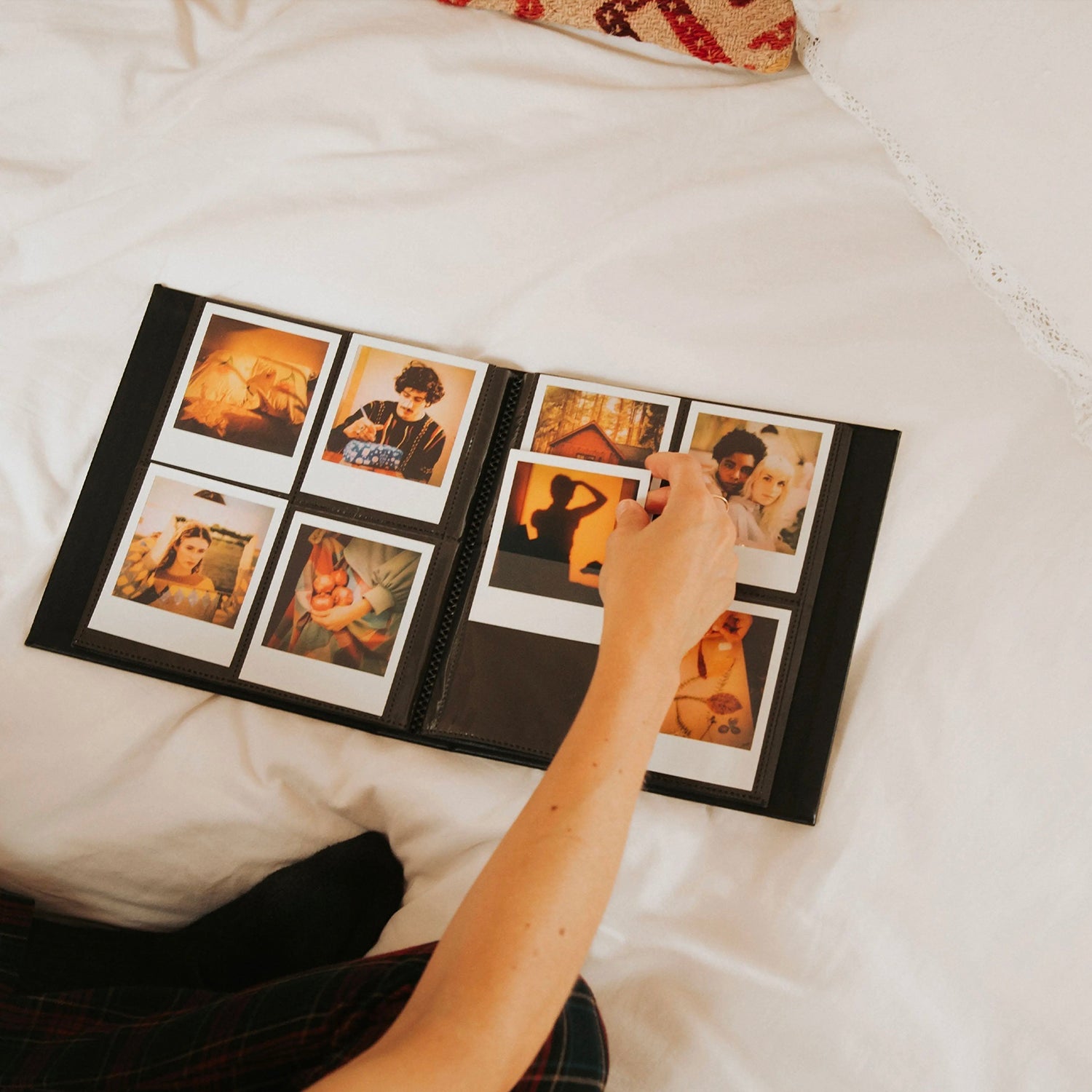 hand putting instant photos into an album